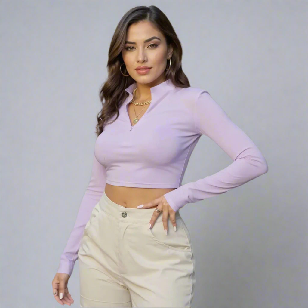 Woman wearing a light purple long-sleeve top and beige pants on a gray background
