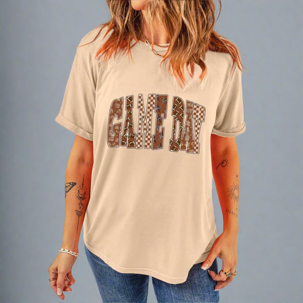 Person wearing a beige t-shirt with 'GAME DAY' printed in brown letters on a beige background