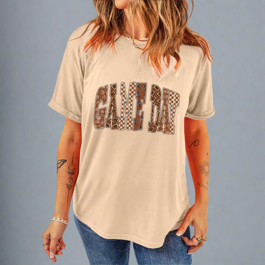 Person wearing a beige t-shirt with 'GAME DAY' printed in brown letters on a beige background
