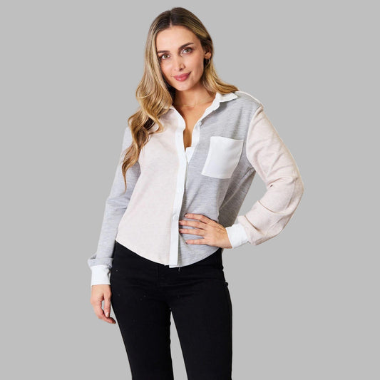 Woman wearing a white and gray checkered shirt with a white blouse underneath, standing against a neutral background.