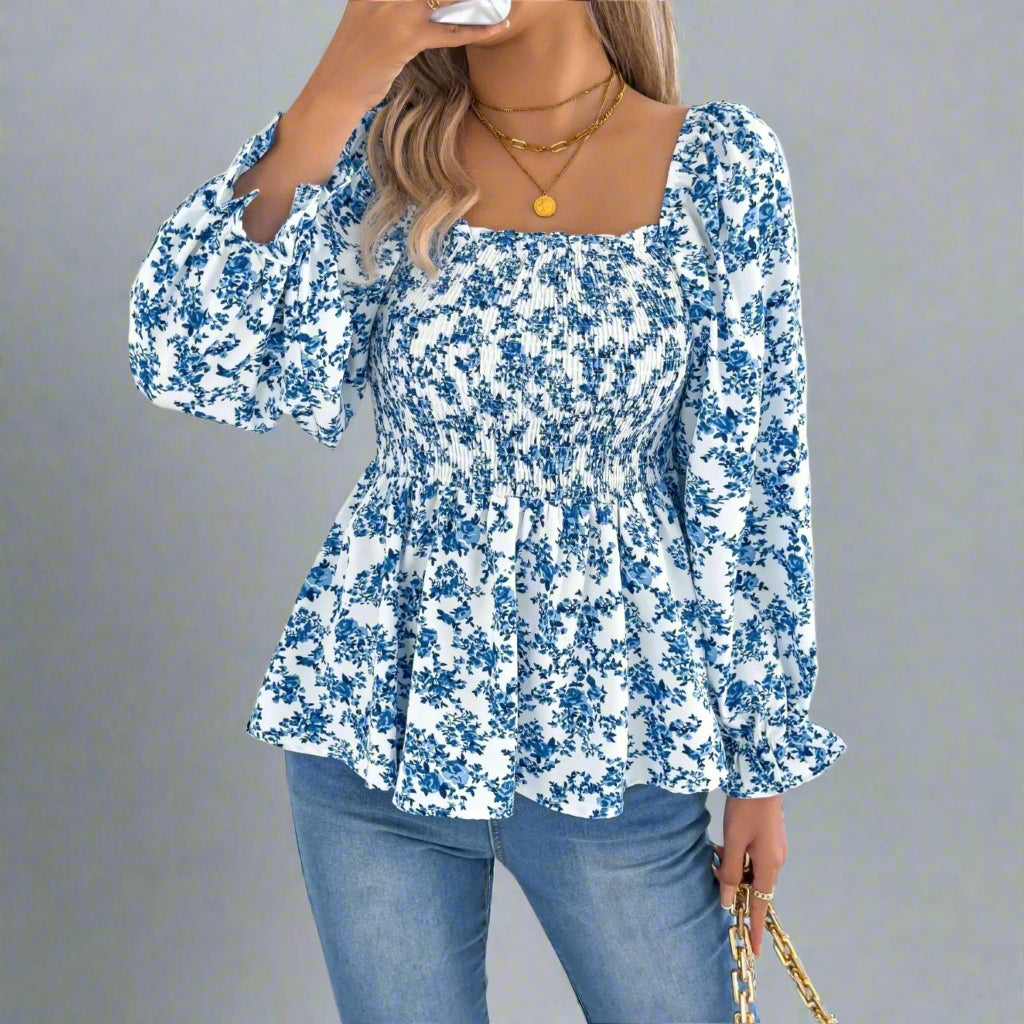 Woman wearing a blue floral blouse and jeans on a white background