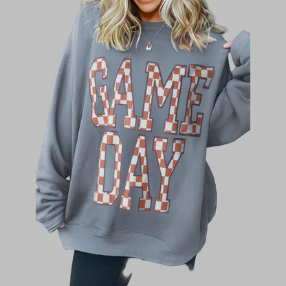 Person wearing a gray sweatshirt with 'GAME DAY' text in checkered letters.
