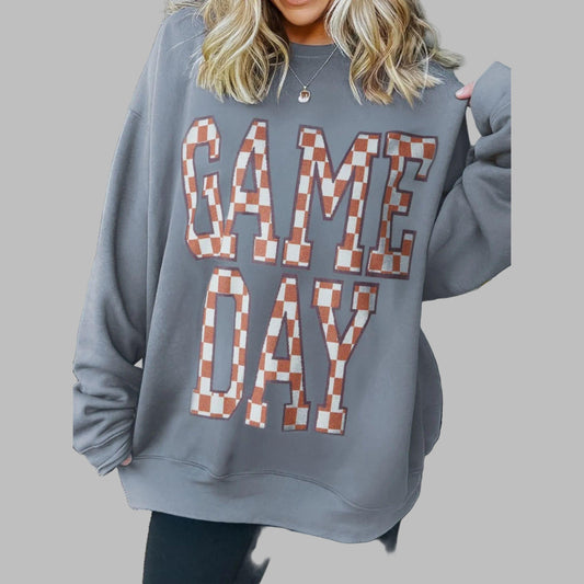 Person wearing a gray sweatshirt with 'GAME DAY' text in checkered letters.