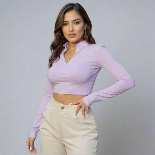 Woman wearing a light purple long-sleeve top and beige pants on a gray background