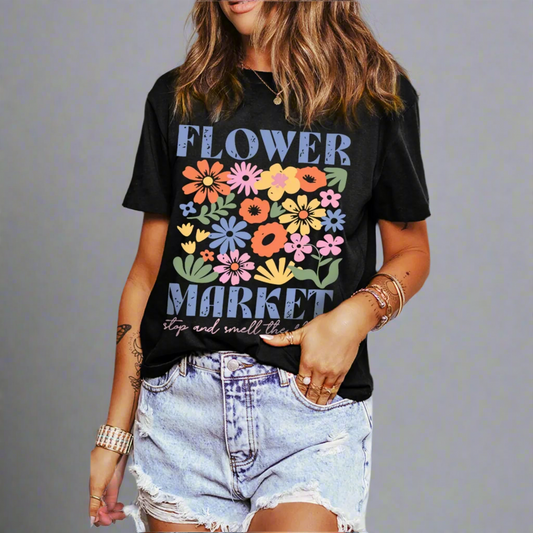 Person wearing a black t-shirt with colorful floral design and text on a gray background
