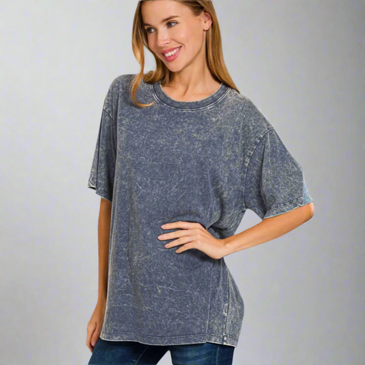 Woman wearing a blue acid-wash t-shirt on a gray background
